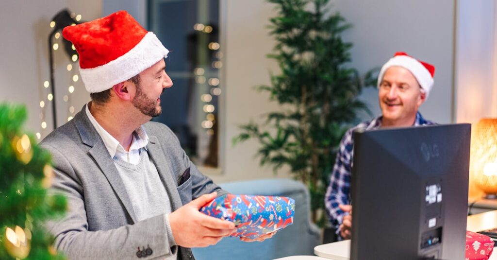 Two men in Santa hats exchanging gifts in a decorated office setting.